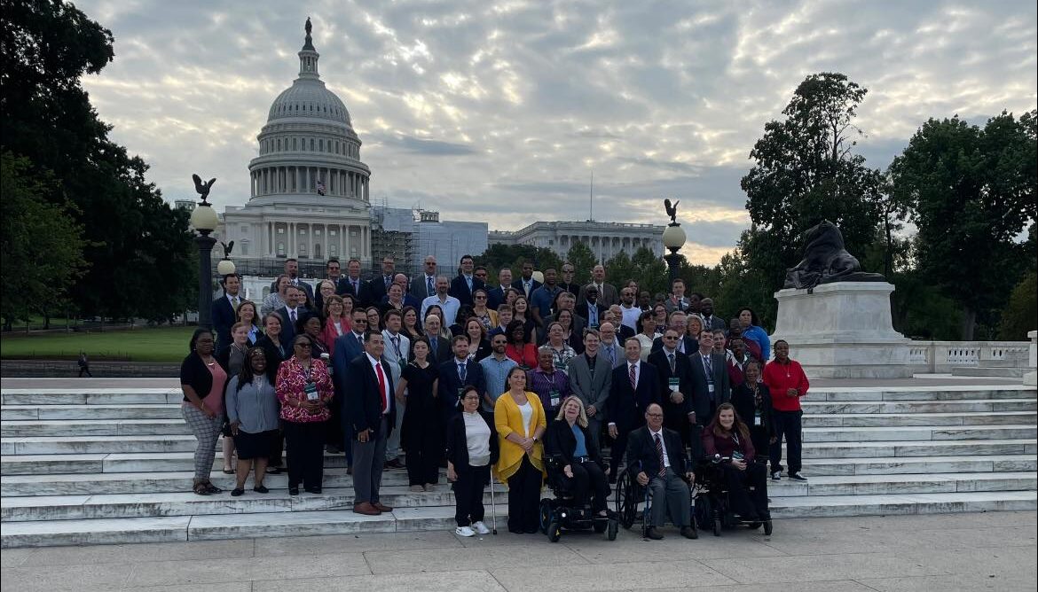 Kylie Moore with a group of disability advocates in front of the DC Capitol.