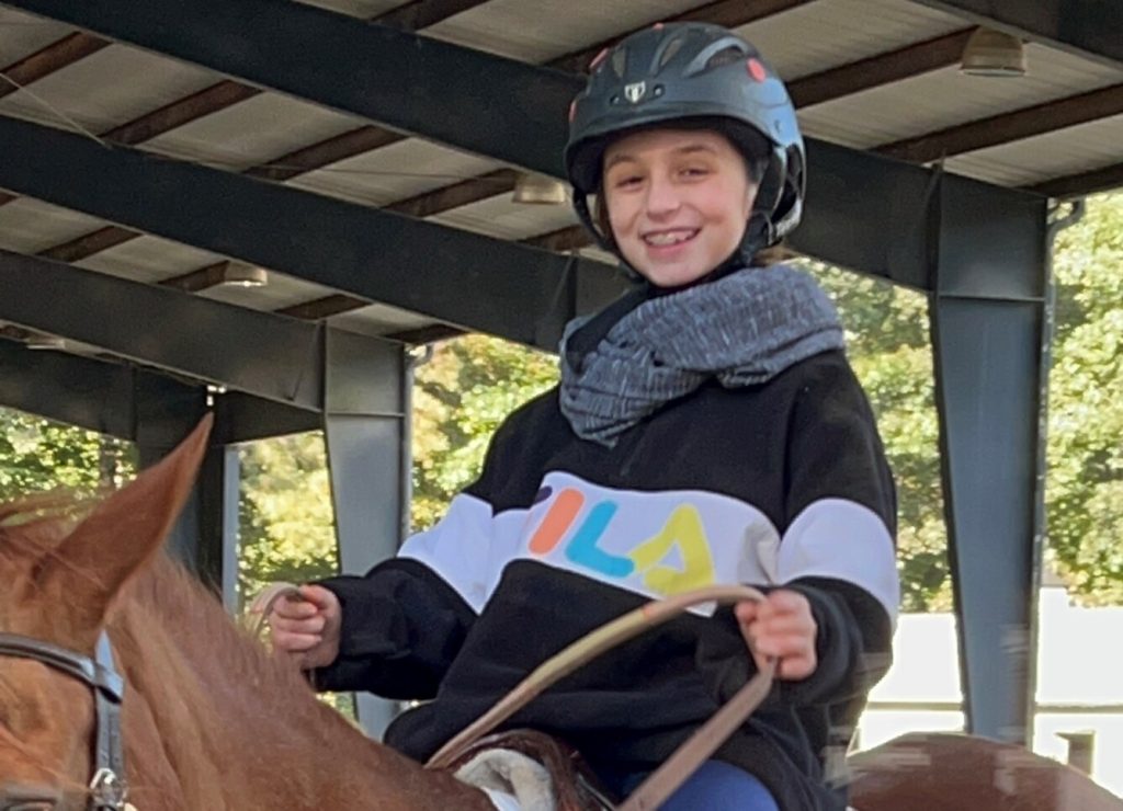 Olivia or Olive is a BDI service participant. She is riding a horse as part of her therapy. her family is able to secure these services thanks to funds provided by Bobby Dodd Institute.