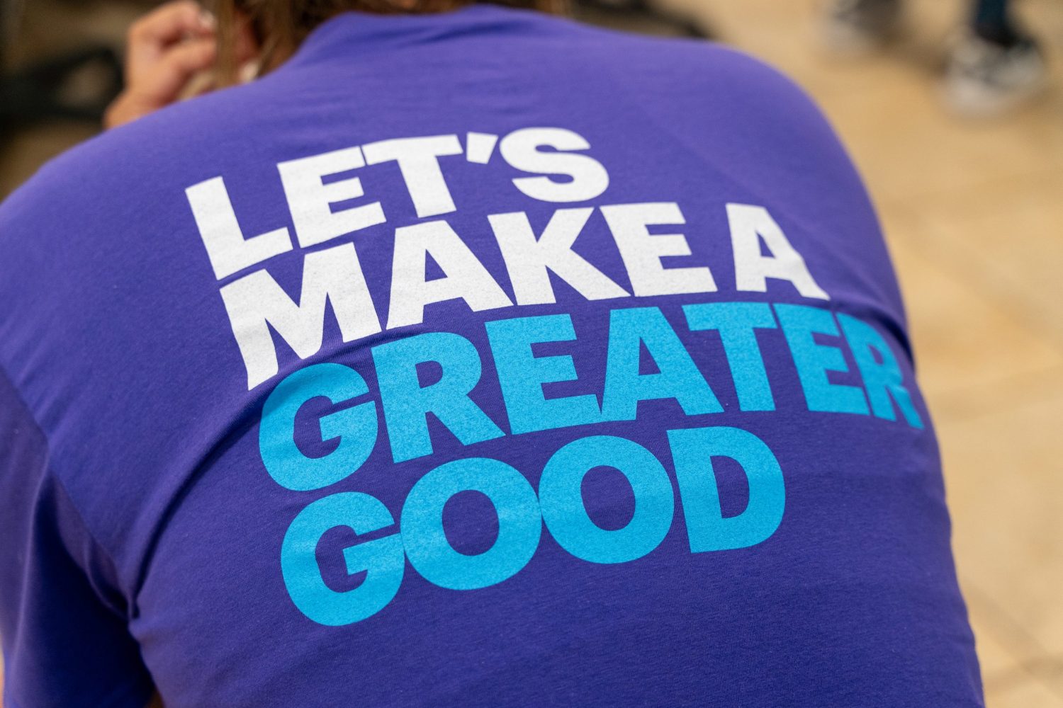 A close up of the back of a t-shirt with a text reding: "Let's make a greater good."