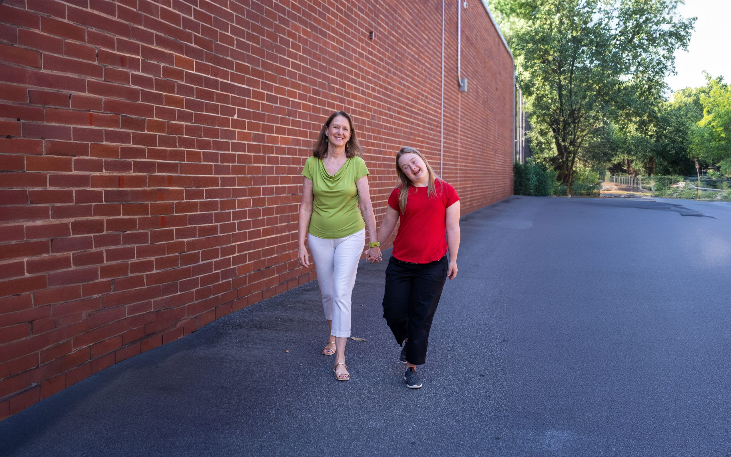 Avery, BDI service participant, and her mom, Sheri, walking and smiling